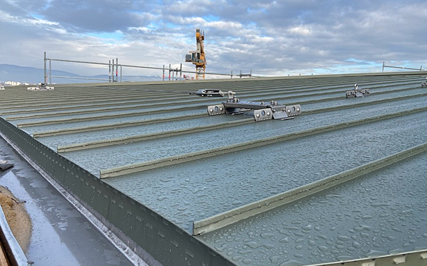 Standing seam metal roof with anchor point and visible moisture risk 