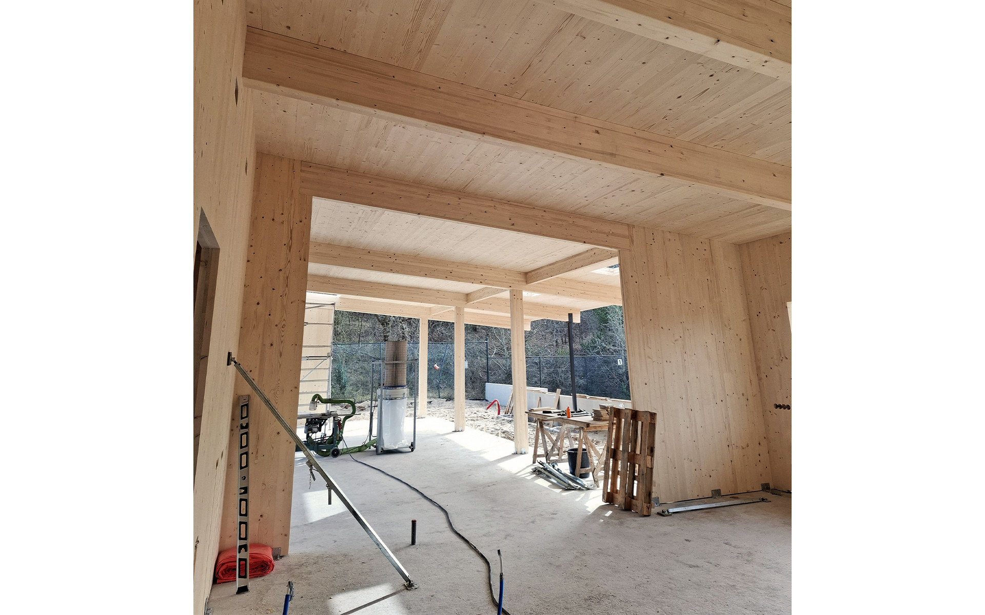 Interior of timber pavilion with exposed CLT panels and glulam beams 
